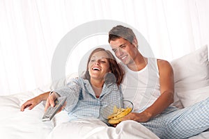 Young couple lying down in white bed