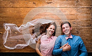 Young couple lying on a floor against wooden background