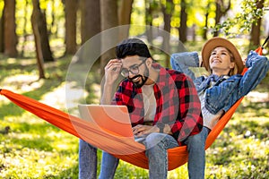 Young couple lying in a hammock and feeling relaxed and enjoyed