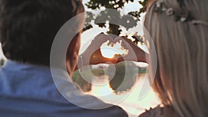 Young couple making a heart shape from their hands.