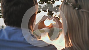 Young couple making a heart shape from their hands.