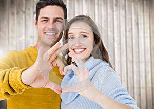 Young couple making a heart symbol with hands