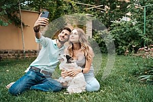Young couple making selfie with their lovely dog