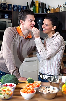 Young couple making and tasting salad