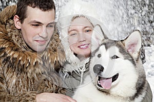 Young couple with a malamute dog