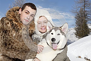 Young couple with a malamute puppy