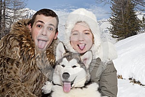 Young couple with a malamute puppy