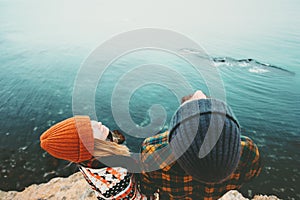 Young Couple Man and Woman holding hands looking at sky above sea