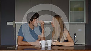 Young couple of man and woman in a kitchen have fun and laugh