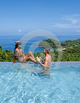 a young couple of men and women with coconut drink at a swimming pool during a vacation