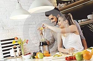 Young couple mixing fruit in a food processor