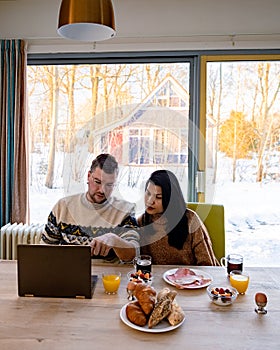 Young couple morning breakfast with laptop.Love,happiness,people and fun working from home concept