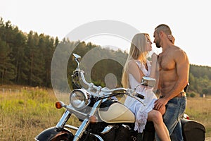 Young couple on a motorcycle in the field