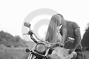 Young couple on a motorcycle in the field