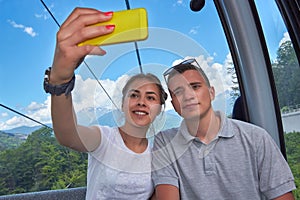 Young couple on mountain lift taking a selfie
