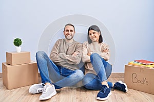 Young couple moving to a new home happy face smiling with crossed arms looking at the camera
