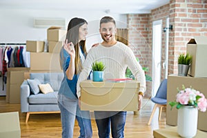 Young couple moving to a new home, hugging in love showing keys of new apartment smiling very happy