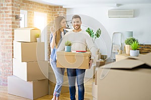 Young couple moving to a new home, hugging in love showing keys of new apartment smiling very happy