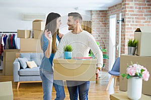 Young couple moving to a new home, hugging in love showing keys of new apartment smiling very happy