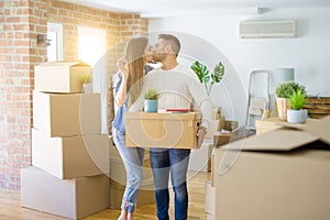 Young couple moving to a new home, hugging in love showing keys of new apartment smiling very happy