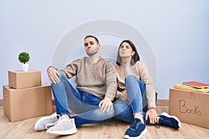 Young couple moving to a new home looking at the camera blowing a kiss on air being lovely and sexy