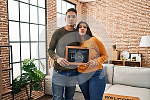 Young couple moving to a new home looking at the camera blowing a kiss being lovely and sexy