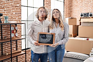 Young couple moving to a new home looking at the camera blowing a kiss being lovely and sexy