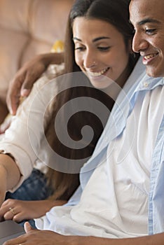 Young couple moving to a new home relaxing sitting on the sofa using computer laptop, smiling happy for moving to new apartment