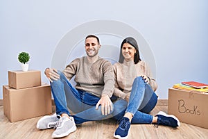 Young couple moving to a new home winking looking at the camera with sexy expression, cheerful and happy face
