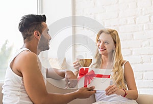 Young Couple Near Window Happy Smile Hispanic Man Woman Hold Present Envelope With Ribbon Lovers In Bedroom