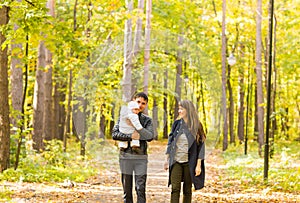 Young couple with newborn baby outdoors in autumn