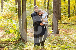 Young couple with newborn baby outdoors in autumn