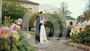 Young couple of newlyweds in love embrace. Groom kisses bride