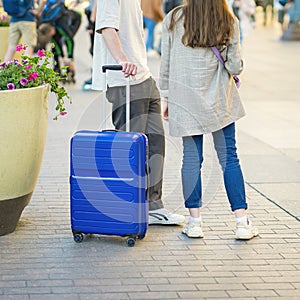 Young couple next to suitcase, waiting for travel, transport at train station