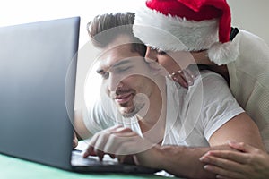 Young couple online shopping on laptop woman hug man