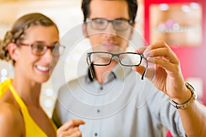 Young couple at optician with glasses