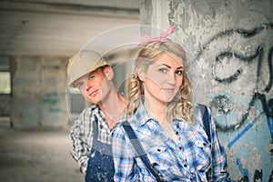 Young couple in overalls and helmets.