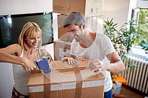 Young couple packing things in boxes.  packing, moving, new beginning, concept