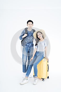 Young couple packing for vacation travel on isolated. Young Asian man and women are preparing for the journey happily on white