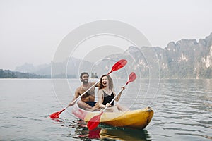 A young couple paddling in a canoe