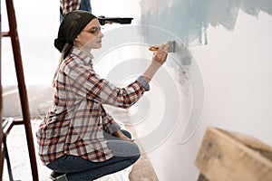 Young couple painting wall at home, working together in room during home repair, renovation improvement. Repair