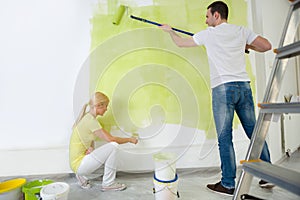 Young couple painting wall