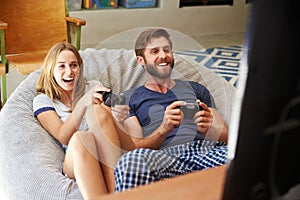 Young Couple In Pajamas Playing Video Game Together