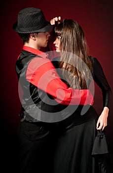 Young couple passion dancing on red light back
