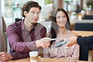 Young Couple paying by credit card in Cafe