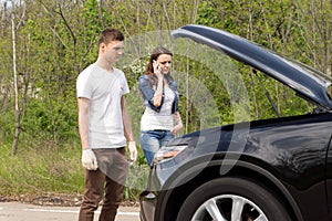 Young couple phoning for roadside assistance