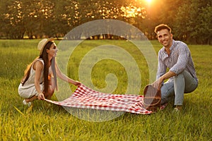 Young couple with picnic blanket and basket