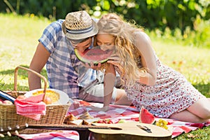 Young couple on a picnic eating watermelon