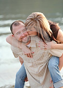 Young couple piggyback ride at beach