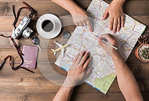 Young couple planning vacation trip with map. Top view.